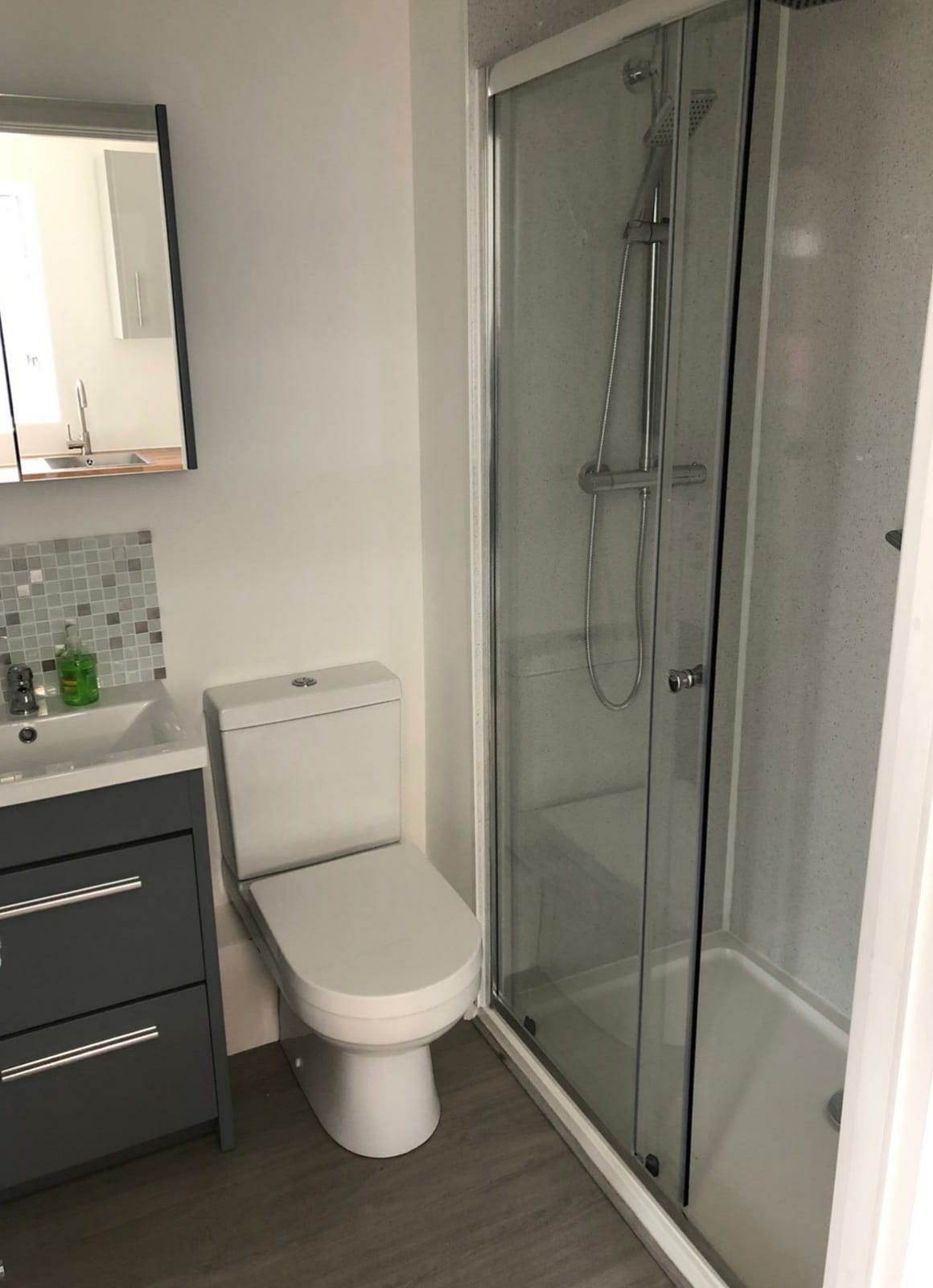Shower room with a walk-in enclosure, grey vanity drawers and a mosaic splashback